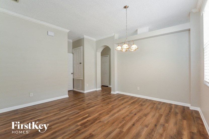 A room with wooden floors and a chandelier hanging from the ceiling.