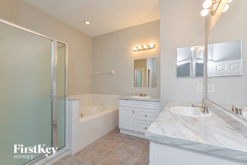 A bathroom with a marble countertop and a walk-in shower.
