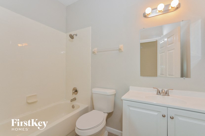 A white bathroom with a toilet, sink, and tub.