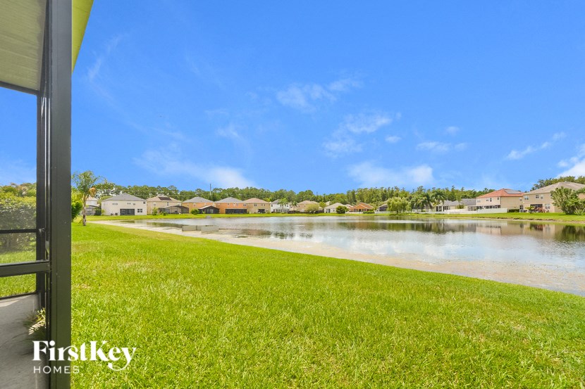 A view of a lake from a house with a FirstKey HOMES sign.