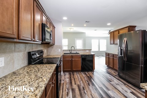 A kitchen with wooden cabinets and black appliances.