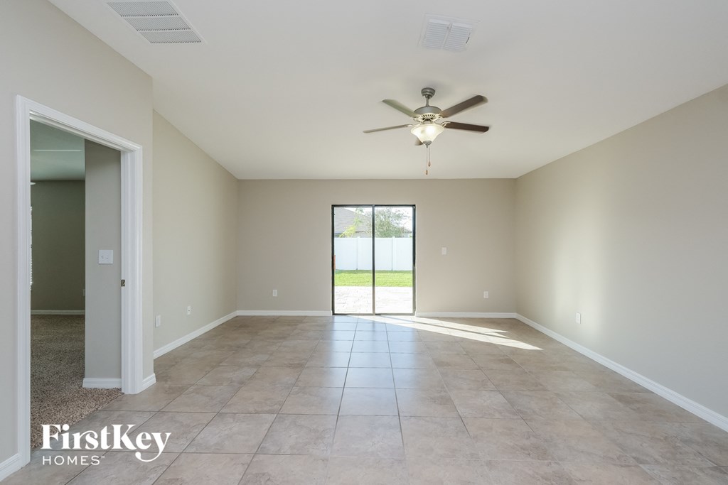an empty living room with a ceiling fan