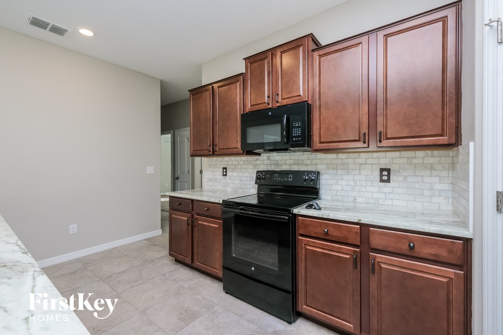 a kitchen with wooden cabinets and black appliances