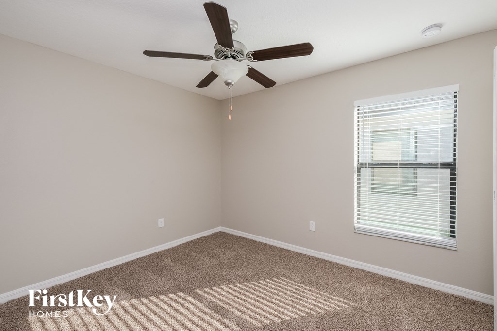 a bedroom with a ceiling fan and a window