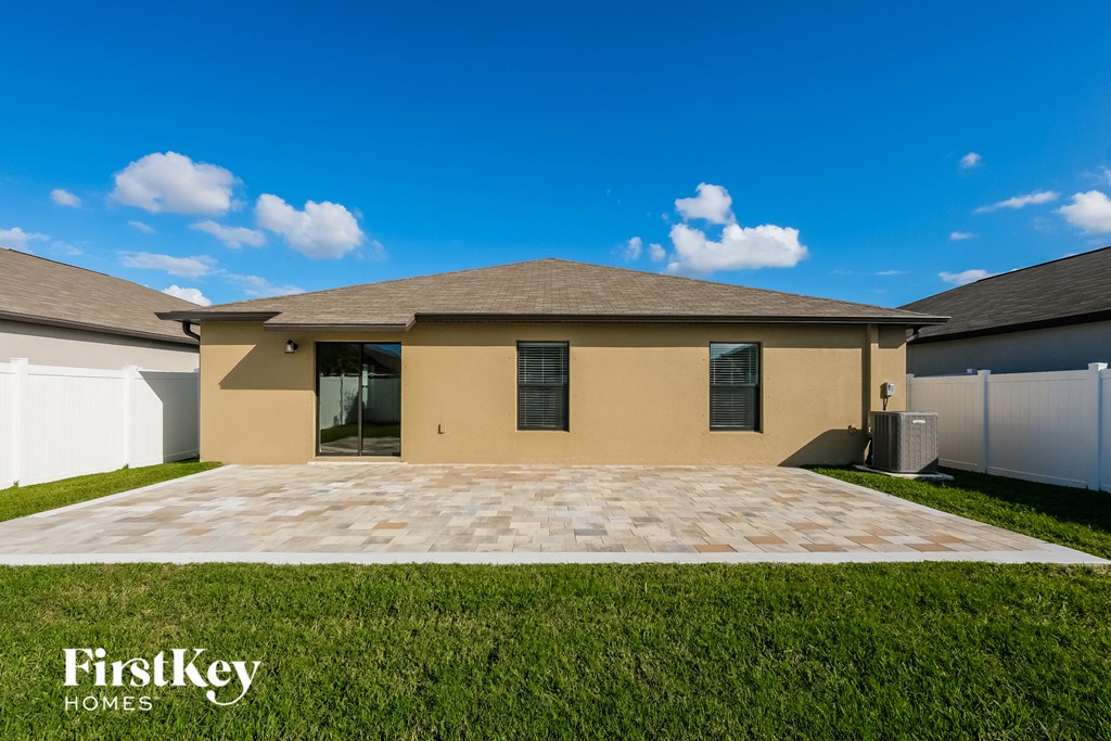 a beige house with a driveway and grass