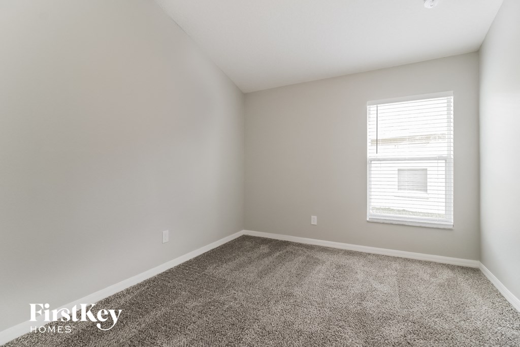 an empty room with carpet and a window