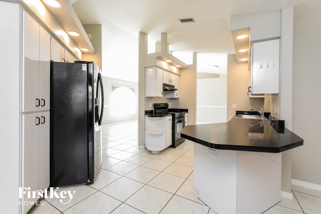a kitchen with a black refrigerator and a counter top