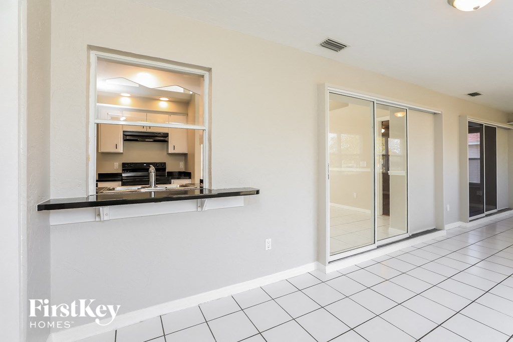 a kitchen with a counter and a glass door to the living room