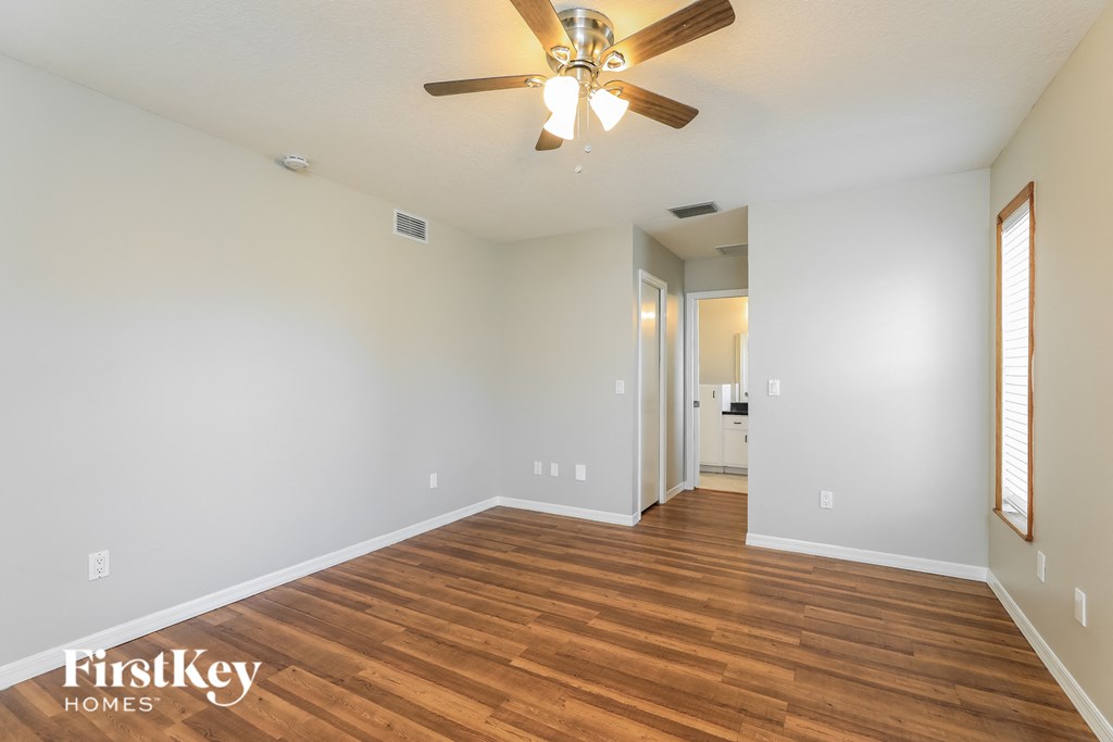 a living room with wood flooring and a ceiling fan