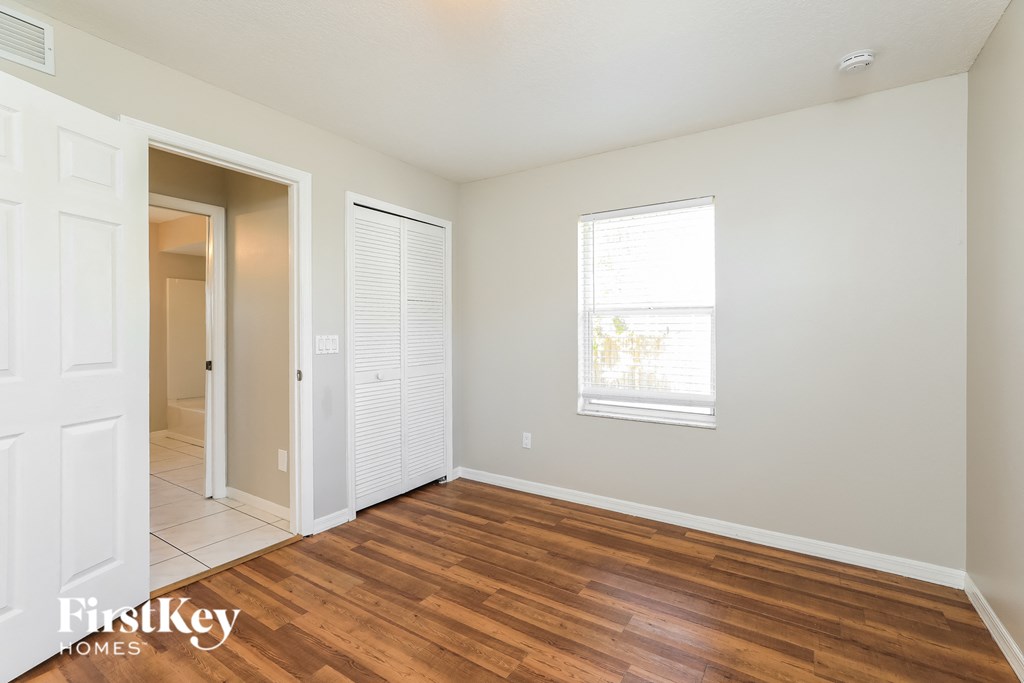 a living room with a hardwood floor and a door to a hallway and a