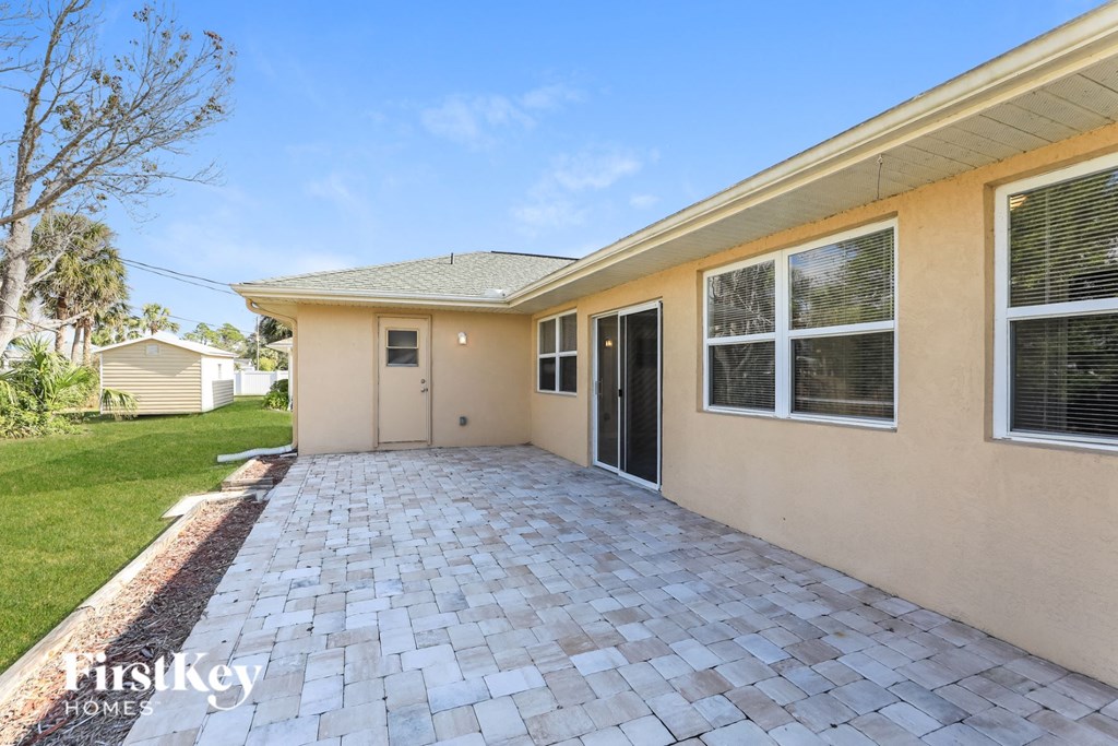 a patio with a driveway and a house next to it