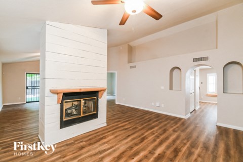 A spacious living room with wood floors and a fireplace.