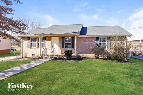 A brick house with a lawn in front.