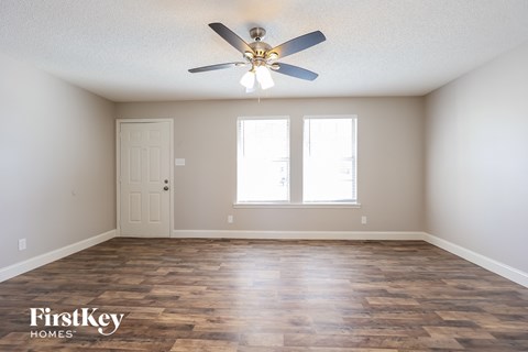 A room with wooden flooring and a ceiling fan.