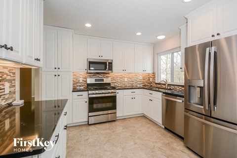 A kitchen with white cabinets and stainless steel appliances.