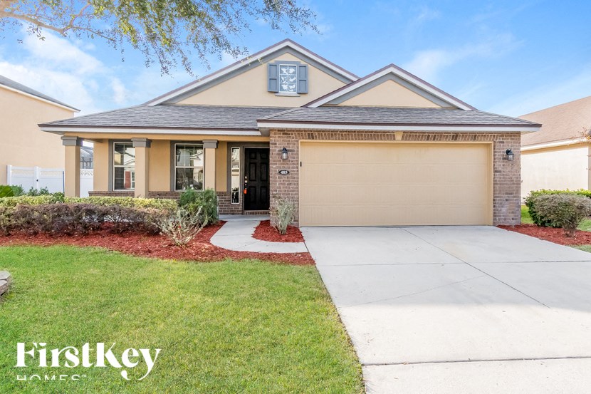 A house with a garage and a driveway in front of it.