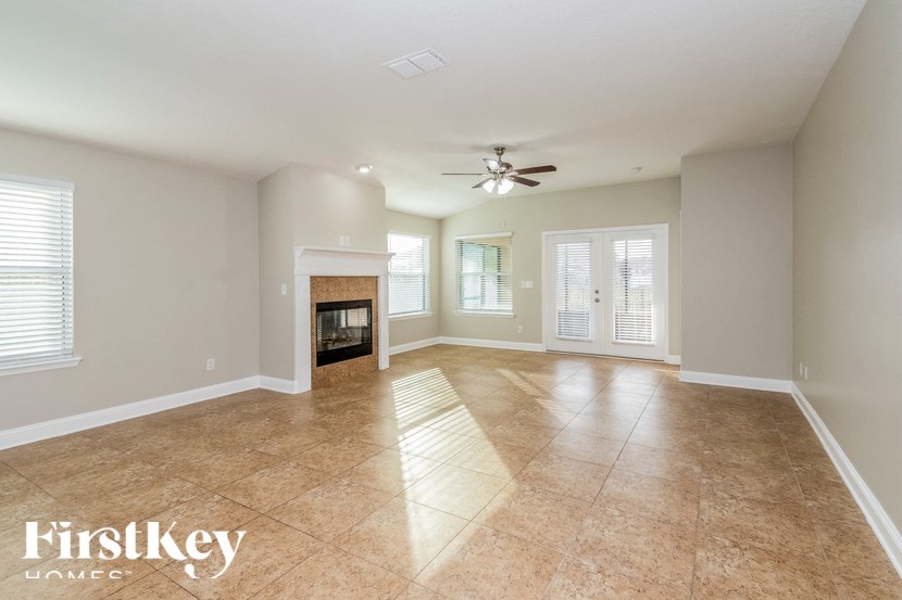 A spacious room with a fireplace and a ceiling fan.