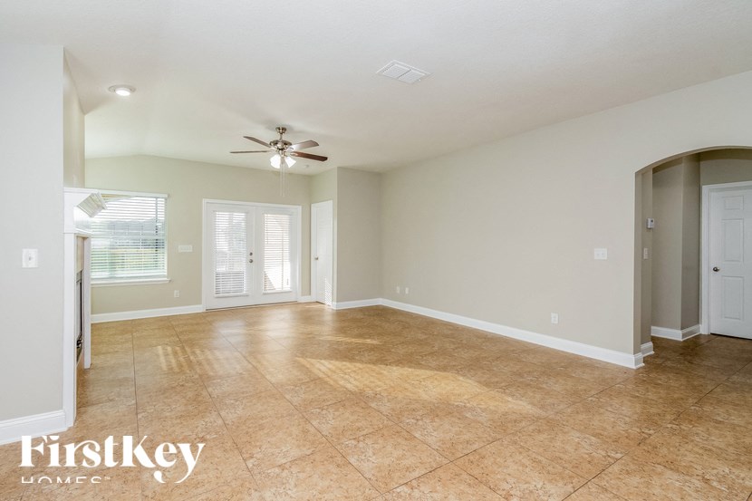 A spacious room with a ceiling fan and tiled flooring.