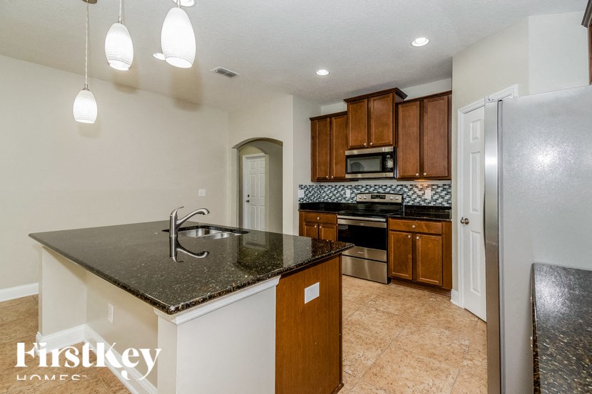 A kitchen with a black granite countertop and wooden cabinets.