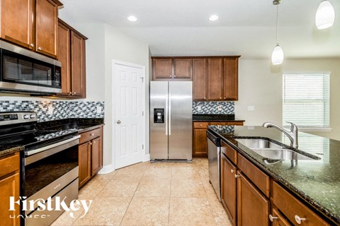 A kitchen with wooden cabinets and a stainless steel refrigerator.