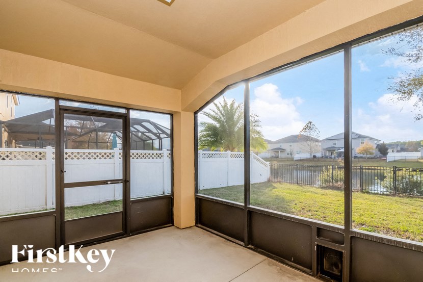 A sunny day outside with a view of a fence and a house.