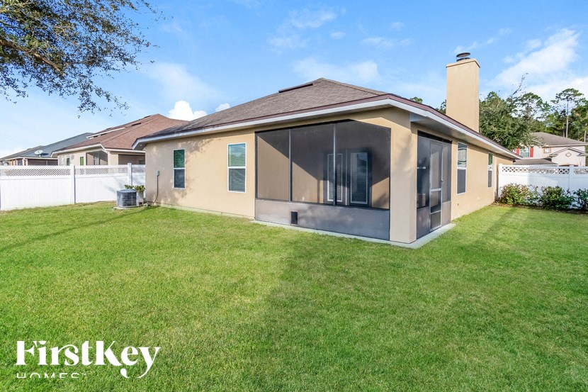 A house with a well-maintained lawn and a clear sky above.