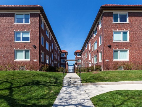 A long brick building with a walkway in between.