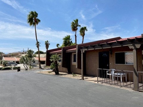 A house with a red roof and a patio with a table and chairs.