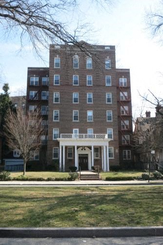 a large brick building with a lawn in front of it