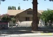 A house with a brown roof and a tree in front.