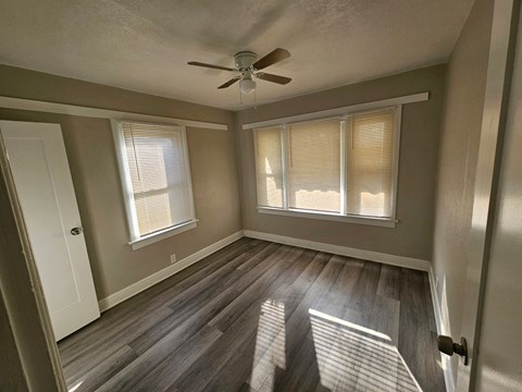 a living room with wood floors and a ceiling fan