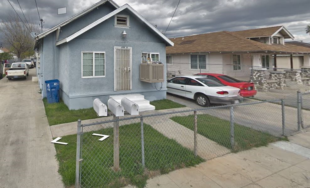 A blue house with a red car parked in front.