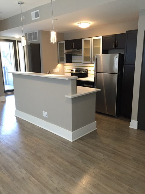 A kitchen with a white island and stainless steel appliances.