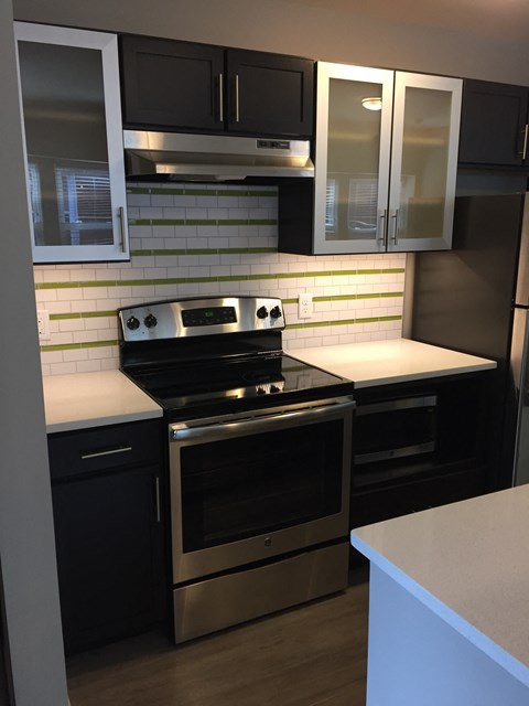 A modern kitchen with a stove top oven and a refrigerator.