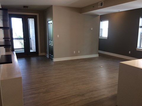 A room with wooden floors and a black door.