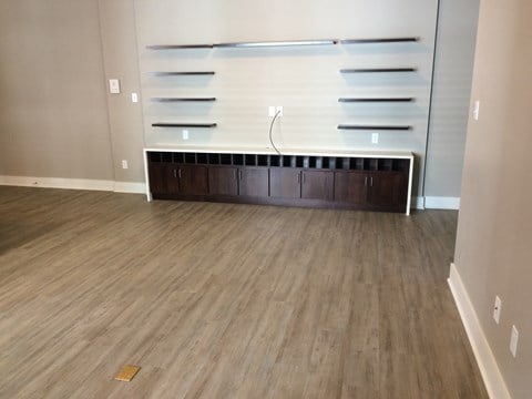 A room with wooden flooring and a long cabinet with drawers.
