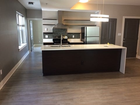 A kitchen with a large island and a refrigerator.