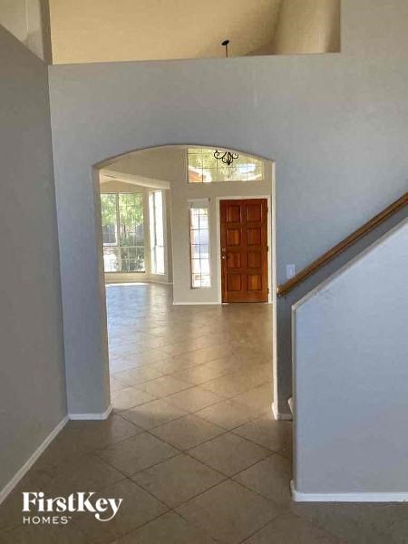 a hallway with a door to a living room and a staircase