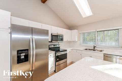 A kitchen with a stainless steel refrigerator and a stainless steel sink.