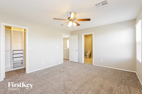 a spacious living room with carpet and a ceiling fan