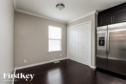 A kitchen with a stainless steel refrigerator and a white door.