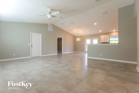 A spacious room with a fan and tiled flooring.