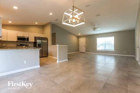 A spacious kitchen and living room with a large island and a ceiling fan.