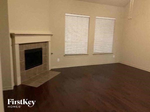 A room with a fireplace and wooden floors.