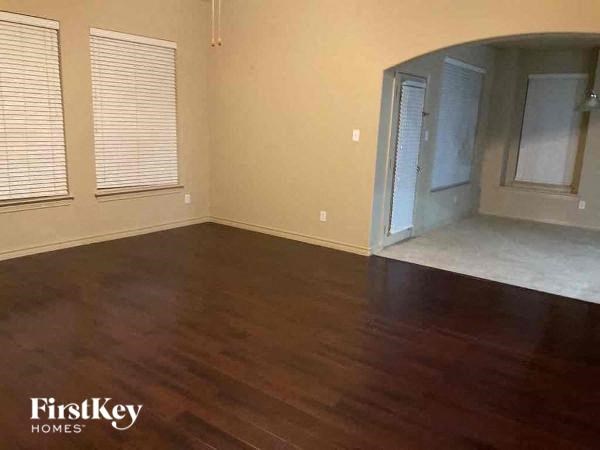 A room with wooden floors and a FirstKey Homes logo.