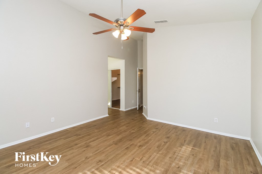 a living room with white walls and a ceiling fan