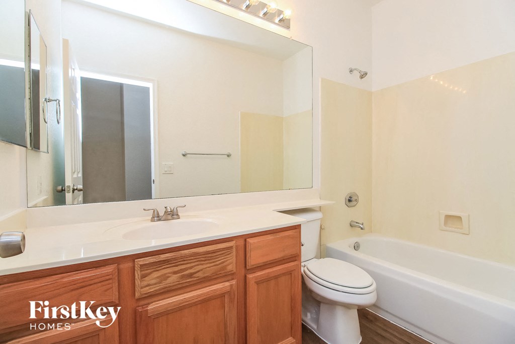 a bathroom with a sink toilet and mirror and a tub