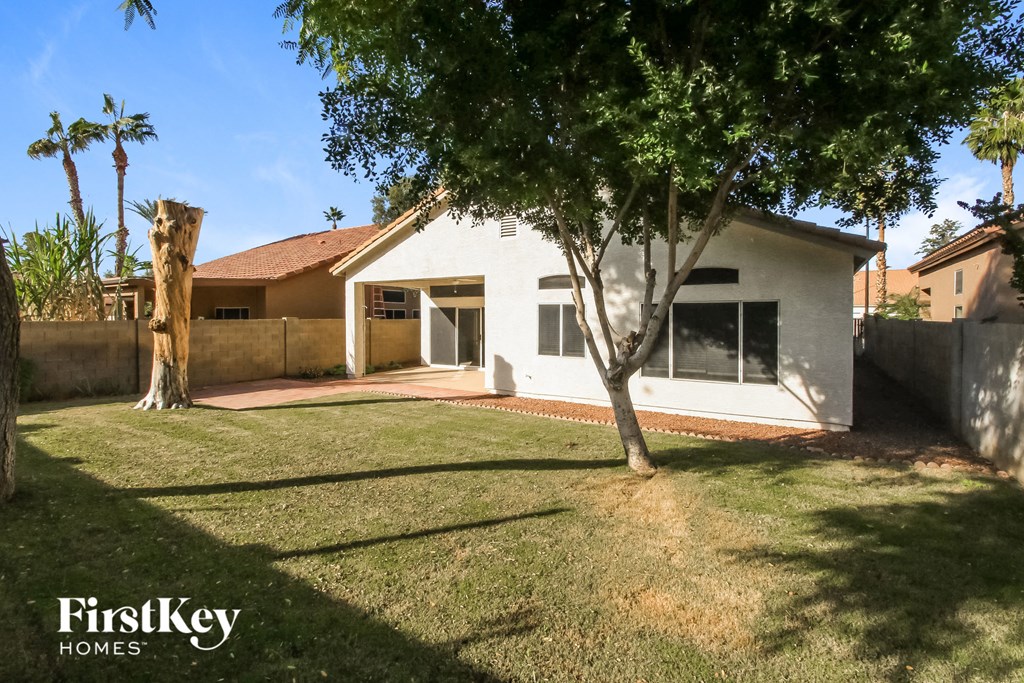 a white house with a yard and a tree