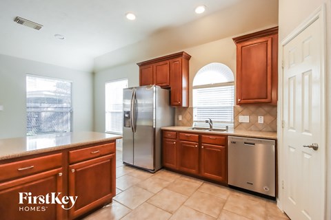 an updated kitchen with stainless steel appliances and wooden cabinets