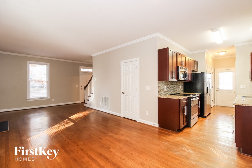 A kitchen with wooden floors and a white door.